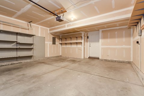 A spacious garage with a concrete floor and walls under construction.