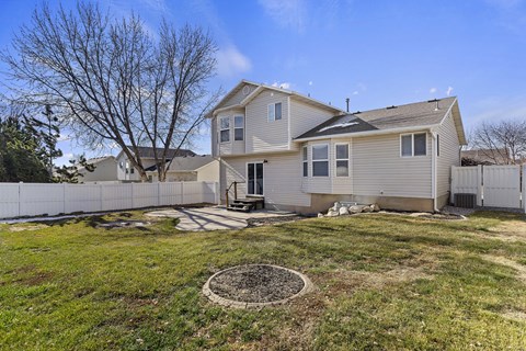 A house with a white fence and a tree in the front yard.