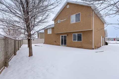 A house with a brown roof and a tree in front of it.