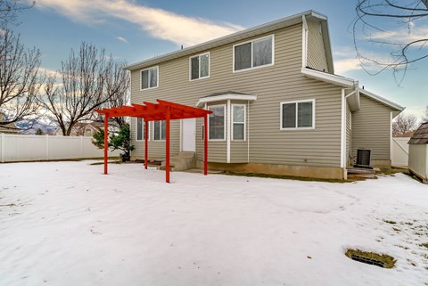 A house with a red pergola in the snow.