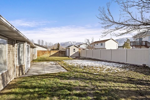the backyard of a house with a yard and a chain link fence and a house