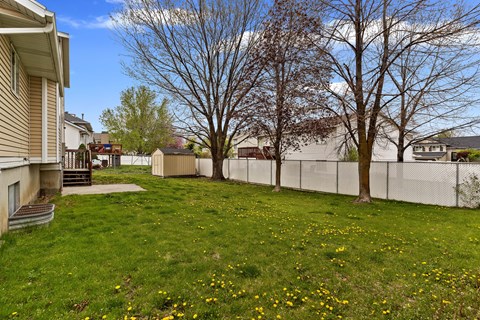 the backyard of a house with a yard and a fence