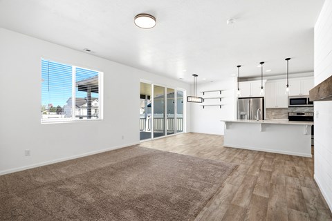A spacious living room with a view of the street outside the window.
