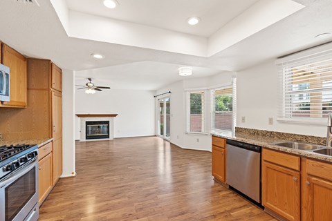 A kitchen with wooden cabinets and a stainless steel dishwasher.