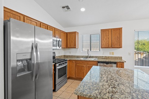 A kitchen with granite countertops and stainless steel appliances.