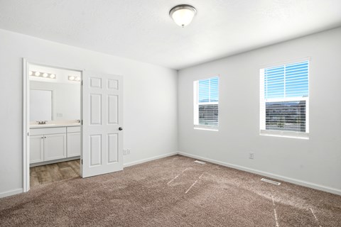 A room with a brown carpet and white walls.