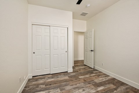 A room with a white door and a wooden floor.
