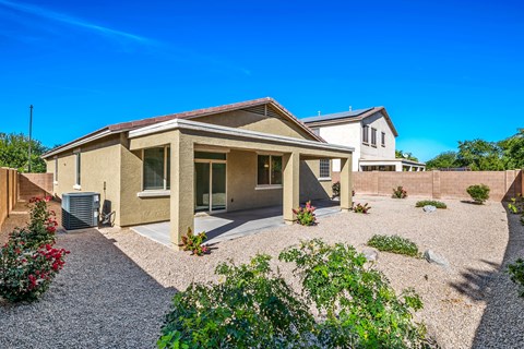 A house with a gravel driveway and landscaping in front.