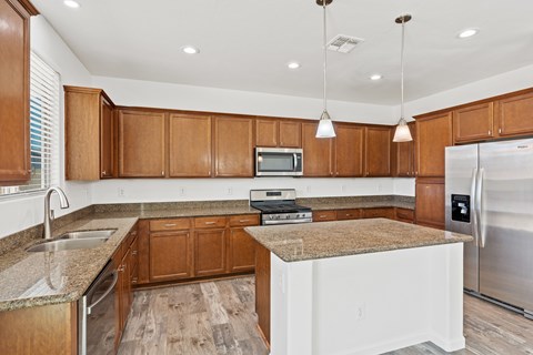 A kitchen with wooden cabinets and a granite countertop.