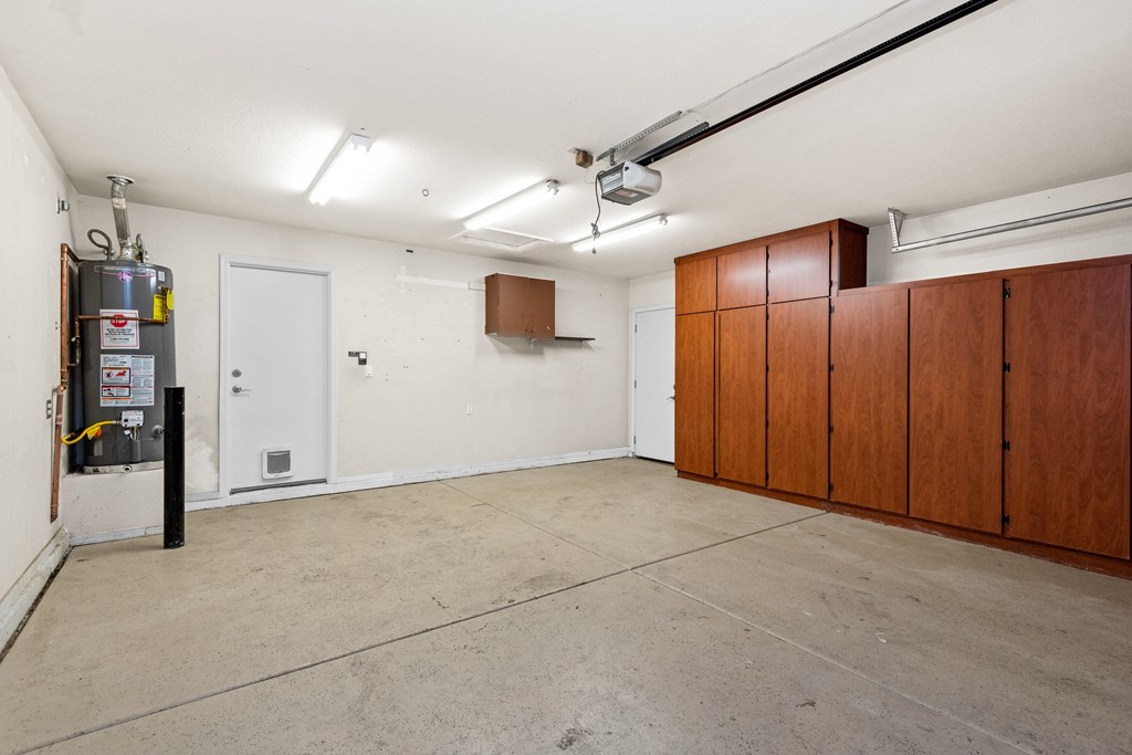 an empty room with white walls and wood cabinets