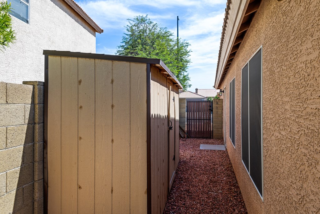 a wooden fence between two houses with a tree in the background
