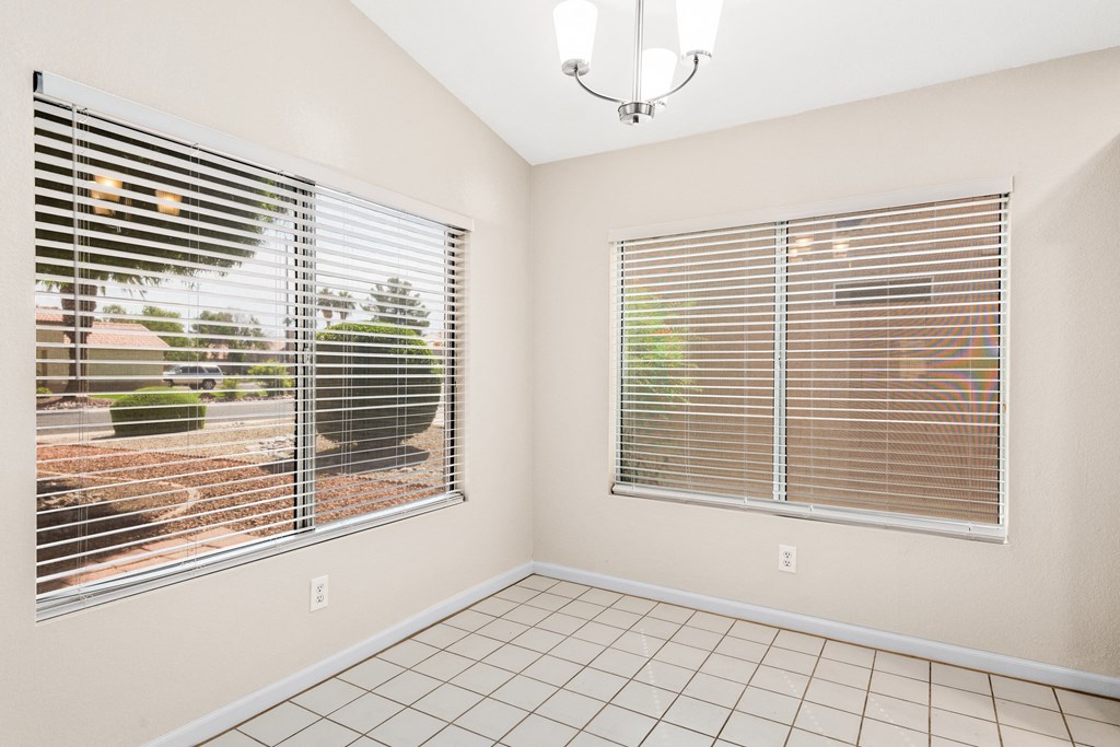 a living room with two windows and a tiled floor