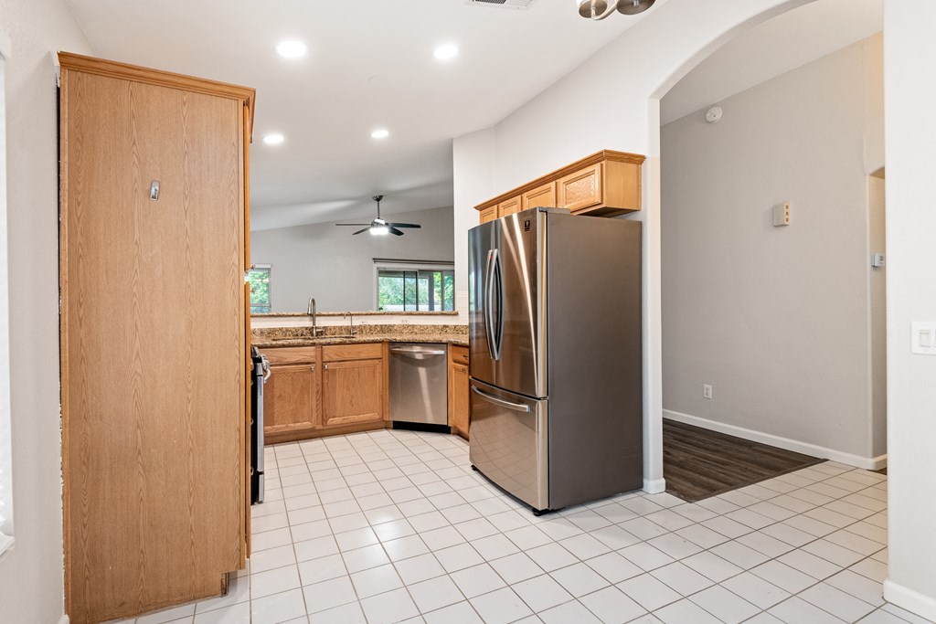 an empty kitchen with stainless steel appliances and wooden cabinets