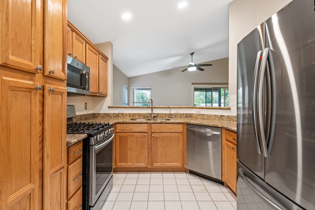 a kitchen with stainless steel appliances and wooden cabinets