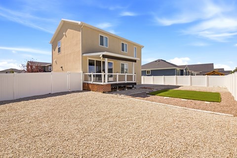 A house with a white fence and a gravel driveway.