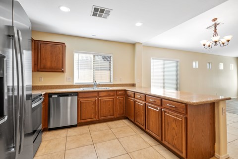 A kitchen with wooden cabinets and a stainless steel refrigerator.