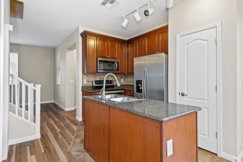 A kitchen with wooden cabinets and a granite countertop.