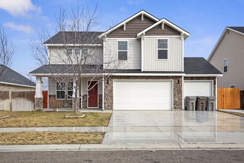 A two-story house with a garage and a driveway.