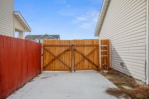 a wooden fence and a sidewalk in front of a house