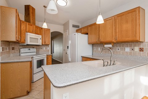 A kitchen with wooden cabinets and a white countertop.