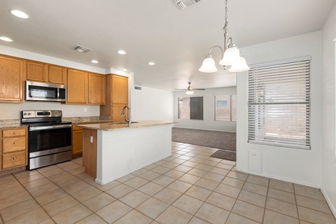 A kitchen with wooden cabinets and a microwave oven.