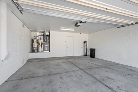A large, empty garage with a concrete floor and white walls.
