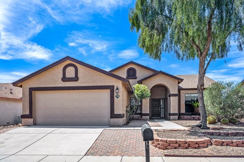 A house with a brown roof and a grey garage door.