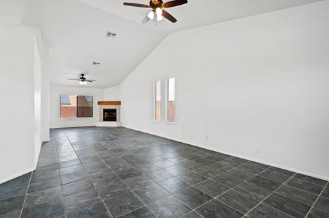 A spacious room with a ceiling fan and tiled flooring.