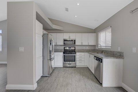 A modern kitchen with stainless steel appliances and white cabinets.
