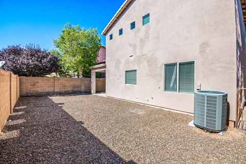the backyard of a house with a trash can in the driveway