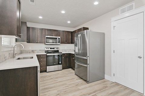 a kitchen with stainless steel appliances and wooden cabinets