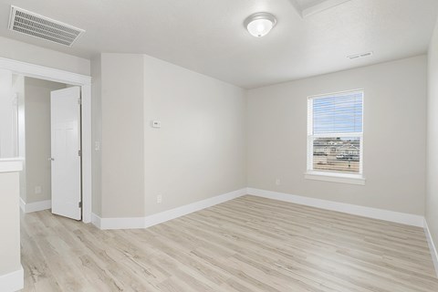 an empty room with white walls and a window