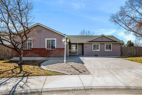 A house with a grey roof and a red brick wall.