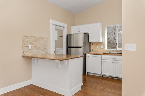 A kitchen with white cabinets and a granite countertop.