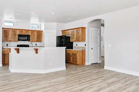 A kitchen with wooden cabinets and a white island.