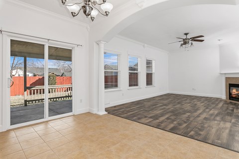 A living room with a fireplace and a fan.