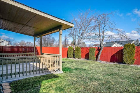 A house with a red fence and a green lawn.
