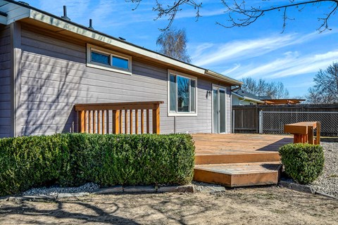 A modern house with a grey exterior and a wooden deck.