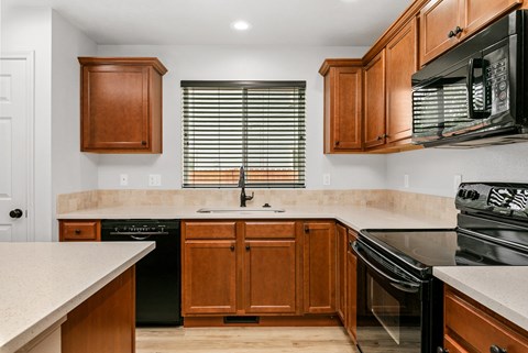 A kitchen with wooden cabinets and black appliances.