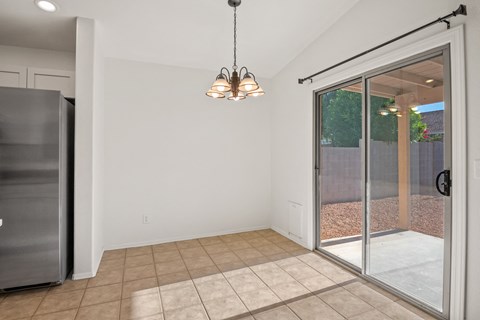 A kitchen with a refrigerator and a chandelier.