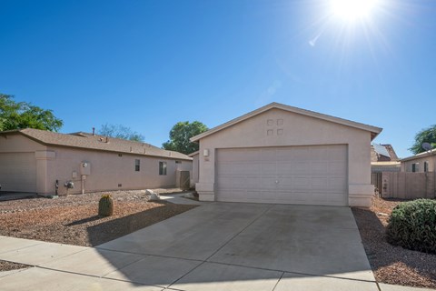 A house with a garage and a driveway in front of it.