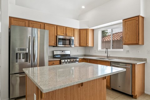 a kitchen with stainless steel appliances and a marble counter top