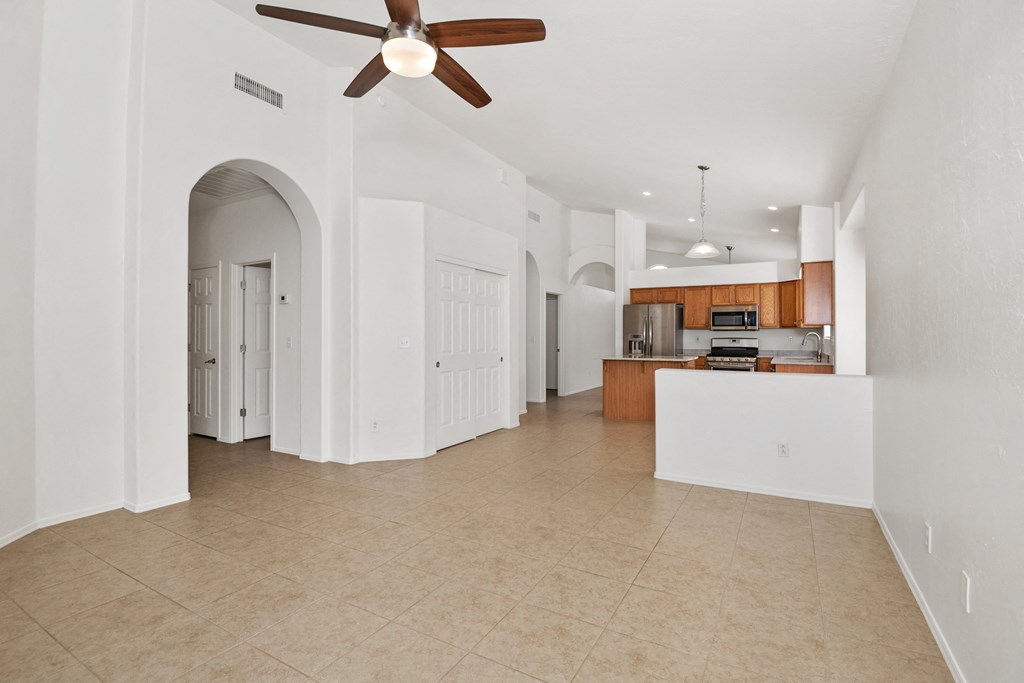an open kitchen and living room with a ceiling fan