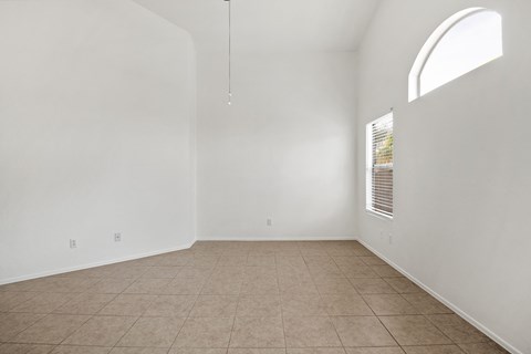 an empty living room with white walls and a window