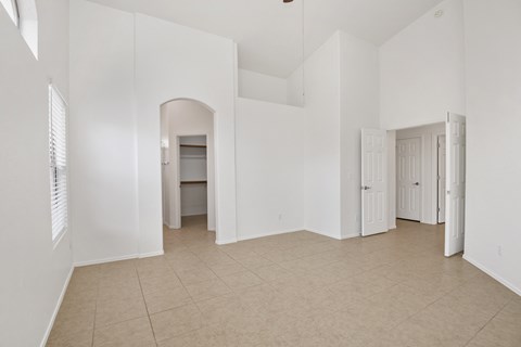 an empty living room with white walls and a tiled floor