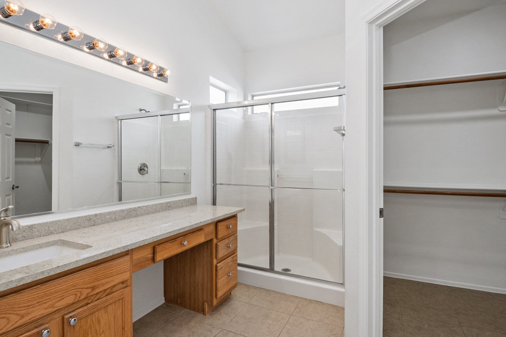 a bathroom with a large shower and a sink and a mirror