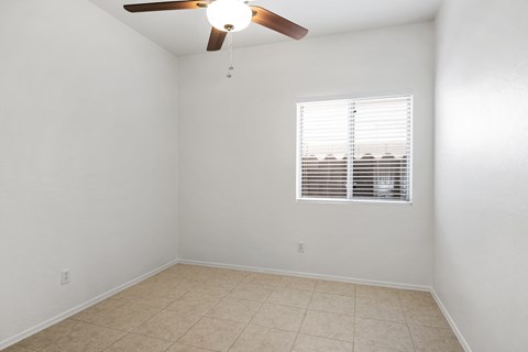 an empty room with a ceiling fan and a window
