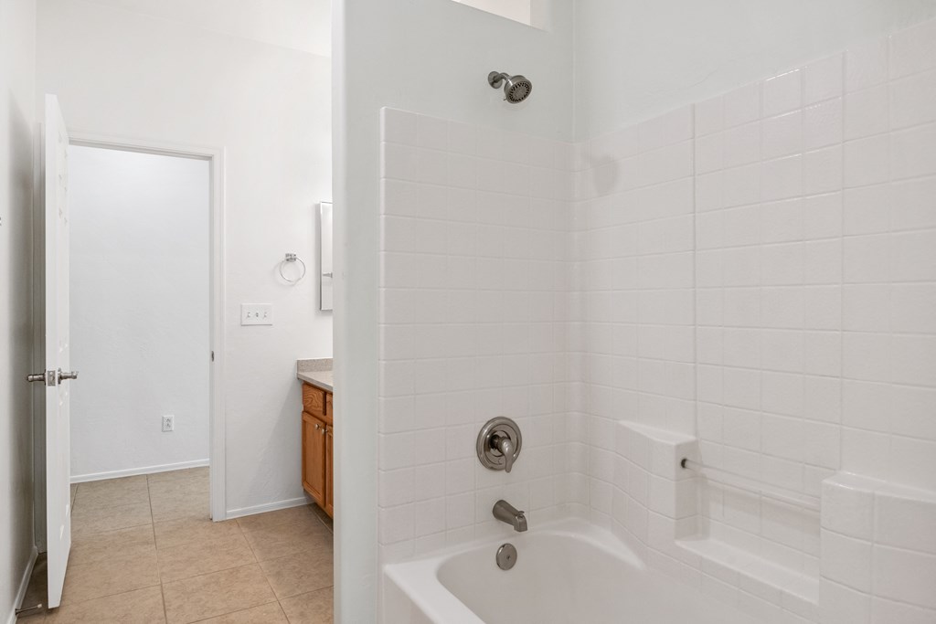 an empty bathroom with a shower and a sink