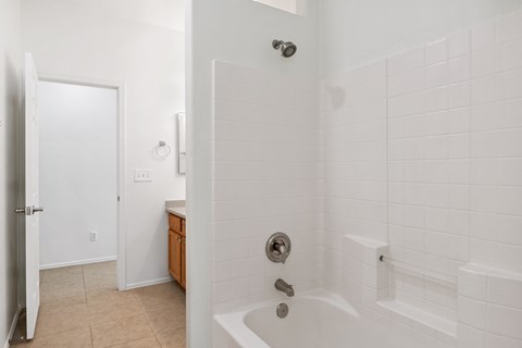 an empty bathroom with a shower and a sink