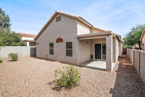 a white house with a gravel yard and a driveway